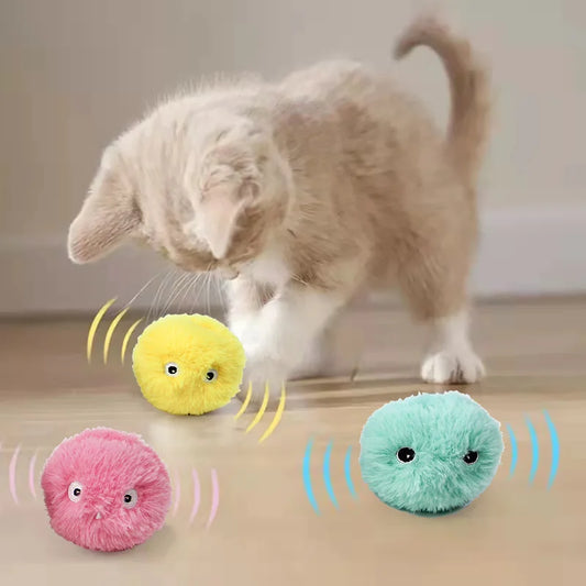 Green, yellow and pink variants of the squeaky pounce ball bouncing in motion, capturing their playful energy. A cute kitten is actively engaged, pouncing and batting at the balls, demonstrating their interactive and stimulating design for feline fun